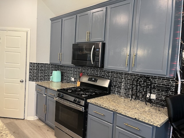 1311 Rosler St, Mansfield, TX 76063 - kitchen with stainless steel gas range oven, gray cabinetry, tasteful backsplash, and light wood-style floors