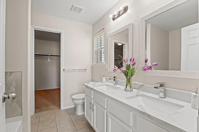 1409 Nicholas Ln, Little Elm, TX 75068 - bathroom featuring double vanity, tile patterned floors, toilet, and a walk in closet