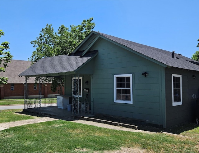 5301 Bonnell Ave, Fort Worth, TX 76107 - rear view of house featuring a lawn, roof with shingles, and an attached carport