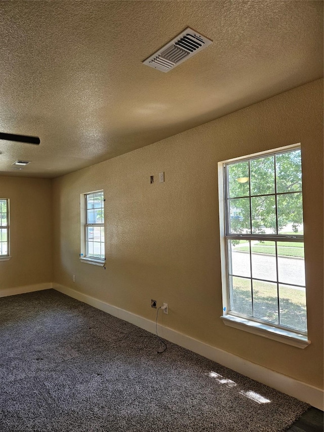 5301 Bonnell Ave, Fort Worth, TX 76107 - empty room featuring plenty of natural light, a textured ceiling, carpet floors, baseboards, and a textured wall