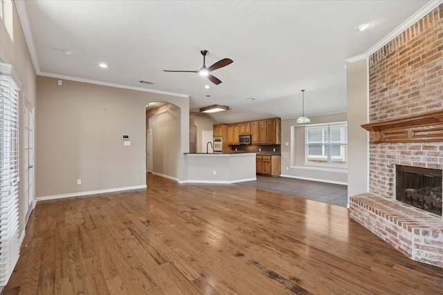 12712 Greenhaven Dr, Frisco, TX 75035 - unfurnished living room with a ceiling fan, arched walkways, crown molding, baseboards, and dark wood finished floors