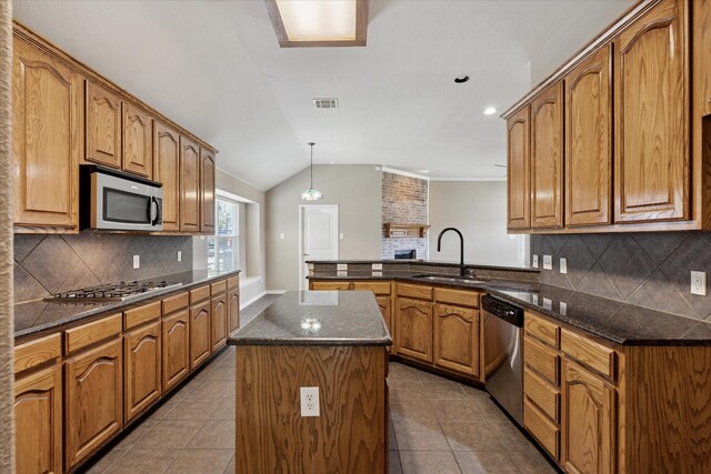 12712 Greenhaven Dr, Frisco, TX 75035 - kitchen featuring stainless steel appliances, a sink, a peninsula, brown cabinets, and tile patterned floors