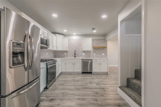 4328 Diaz Ave, Fort Worth, TX 76107 - kitchen featuring stainless steel appliances, a sink, white cabinets, light countertops, and decorative backsplash