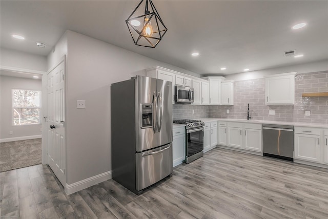4328 Diaz Ave, Fort Worth, TX 76107 - kitchen featuring stainless steel appliances, a sink, white cabinets, light wood-style floors, and recessed lighting