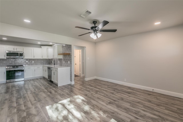 4328 Diaz Ave, Fort Worth, TX 76107 - kitchen featuring stainless steel appliances, a sink, light countertops, wood finished floors, and baseboards