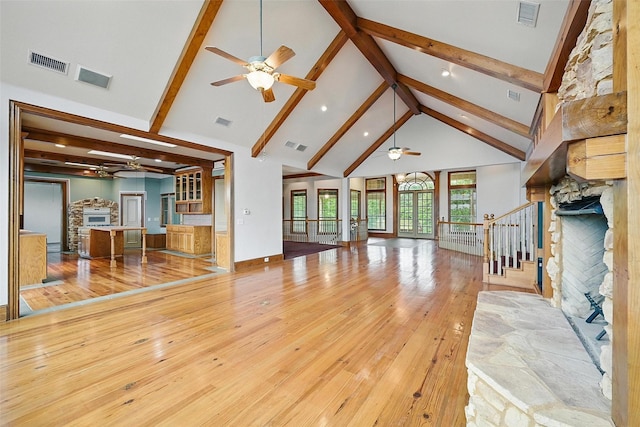 661 Diamond Point Dr, Oak Point, TX 75068 - unfurnished living room featuring a ceiling fan, beamed ceiling, a stone fireplace, high vaulted ceiling, and hardwood / wood-style floors