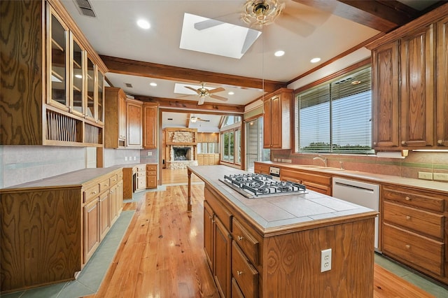 661 Diamond Point Dr, Oak Point, TX 75068 - kitchen featuring ceiling fan, stainless steel gas cooktop, a skylight, light wood-style floors, and beamed ceiling