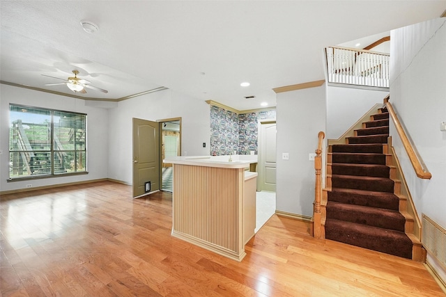 661 Diamond Point Dr, Oak Point, TX 75068 - kitchen featuring crown molding, light wood-style floors, a ceiling fan, light countertops, and a center island