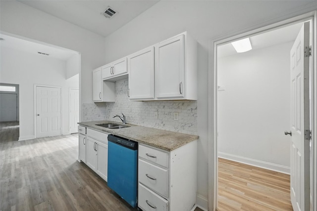 710 W Owing St, Denison, TX 75020 - kitchen with dishwasher, light wood-style floors, decorative backsplash, and white cabinetry
