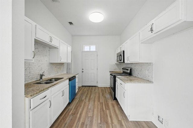 710 W Owing St, Denison, TX 75020 - kitchen featuring stainless steel appliances, decorative backsplash, and white cabinetry