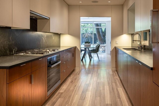4335 Rawlins St, Dallas, TX 75219 - kitchen with oven, a sink, under cabinet range hood, modern cabinets, and recessed lighting