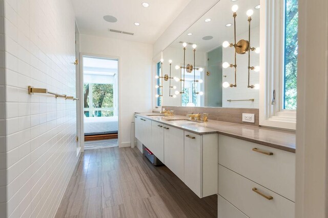 4335 Rawlins St, Dallas, TX 75219 - ensuite bathroom with vanity, wood finished floors, tasteful backsplash, and recessed lighting
