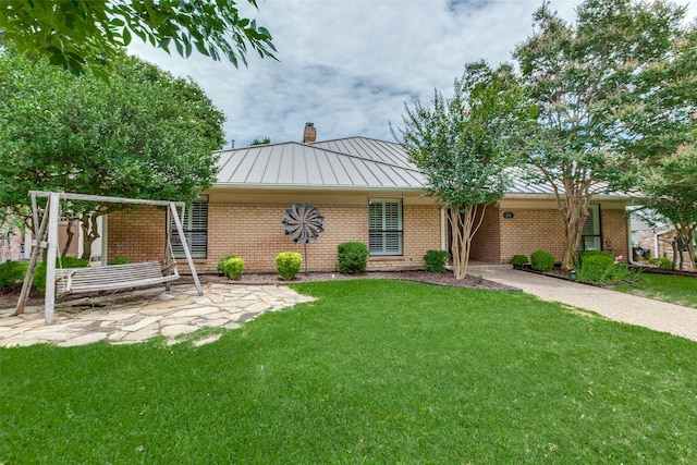 206 Crooked Creek Dr, Richardson, TX 75080 - view of front of home with a standing seam roof, a chimney, brick siding, and a front yard