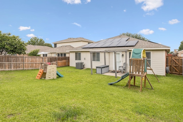 8824 Wagon Trl, Cross Roads, TX 76227 - back of house featuring cooling unit, roof mounted solar panels, and roof with shingles