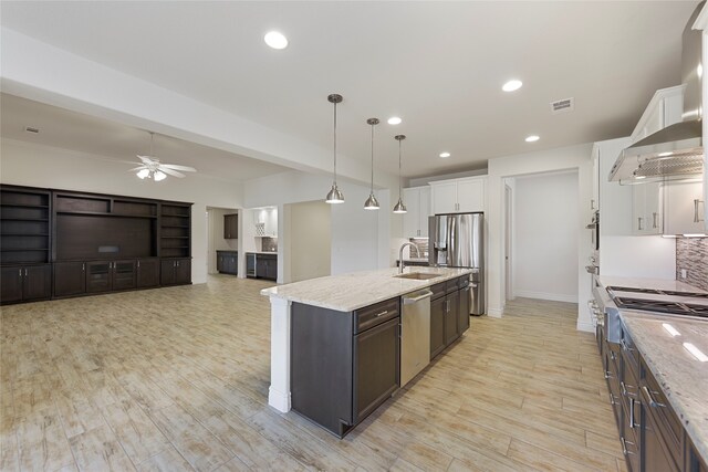 9921 Flint Way, Denton, TX 76207 - kitchen with stainless steel appliances, white cabinets, a ceiling fan, an island with sink, and a sink