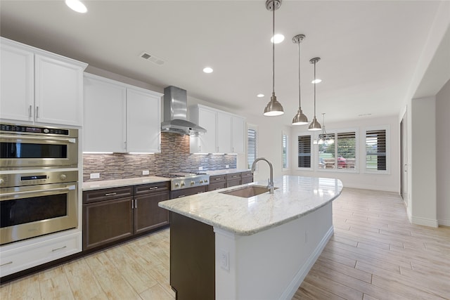 9921 Flint Way, Denton, TX 76207 - kitchen with a sink, wall chimney exhaust hood, appliances with stainless steel finishes, decorative backsplash, and baseboards