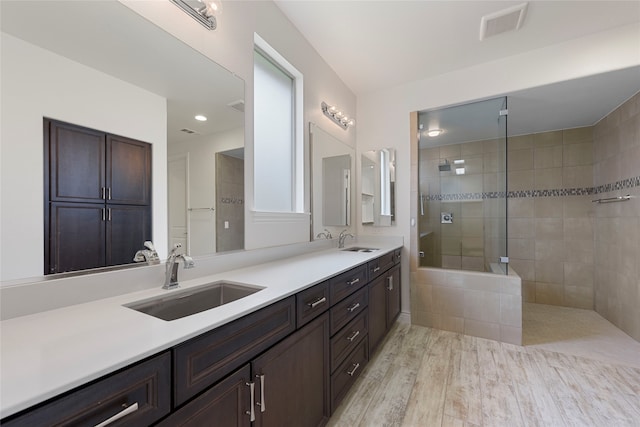 9921 Flint Way, Denton, TX 76207 - bathroom featuring walk in shower, double vanity, and wood finished floors