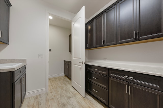 9921 Flint Way, Denton, TX 76207 - kitchen featuring light countertops, light wood-type flooring, and dark brown cabinetry