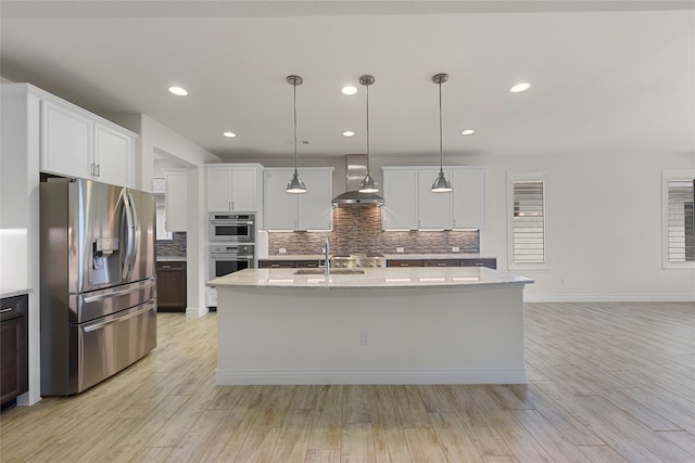 9921 Flint Way, Denton, TX 76207 - kitchen with stainless steel appliances, wall chimney exhaust hood, tasteful backsplash, light wood finished floors, and recessed lighting