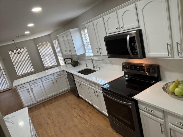 4026 Red Rock Dr, Heartland, TX 75126 - kitchen with black appliances, a sink, recessed lighting, a peninsula, and light countertops