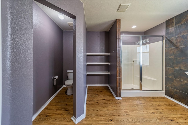 4026 Red Rock Dr, Heartland, TX 75126 - bathroom with a stall shower, toilet, wood finished floors, and baseboards
