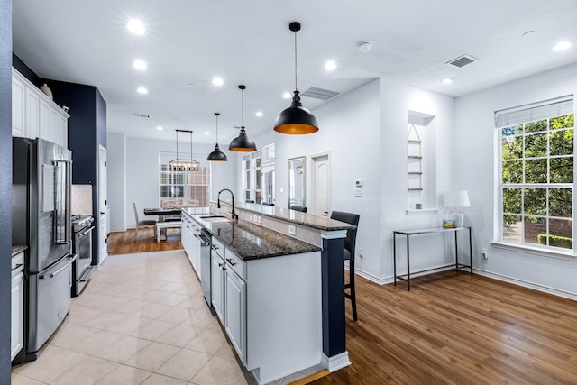 15763 Spectrum Dr Unit 93, Addison, TX 75001 - kitchen featuring a sink, appliances with stainless steel finishes, a breakfast bar area, a spacious island, and white cabinets