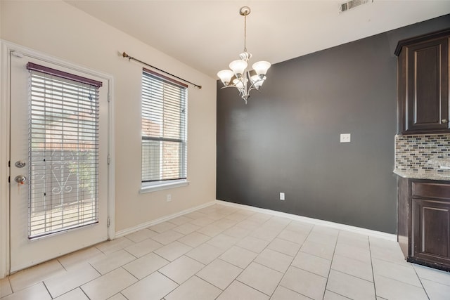 4651 Penelope Ln, Plano, TX 75024 - unfurnished dining area with a chandelier, light tile patterned floors, and baseboards