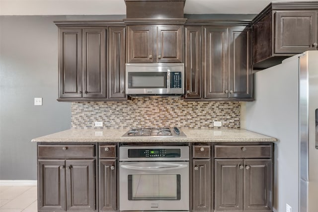 4651 Penelope Ln, Plano, TX 75024 - kitchen with stainless steel appliances, dark brown cabinets, decorative backsplash, and baseboards