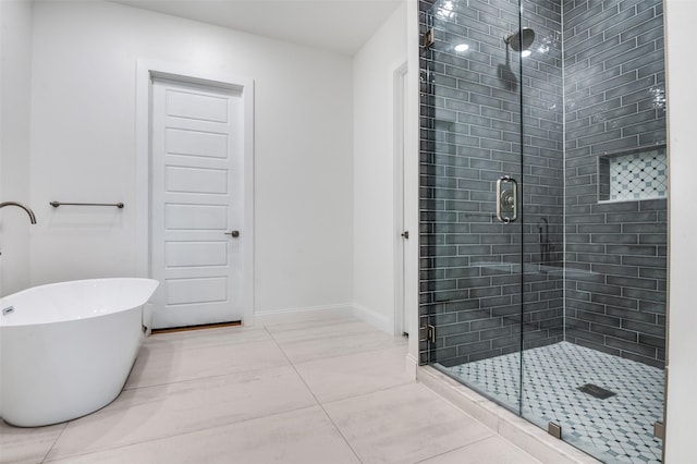 319 Bounding Main St, Gun Barrel City, TX 75156 - bathroom featuring a shower stall, tile patterned flooring, a freestanding bath, and baseboards