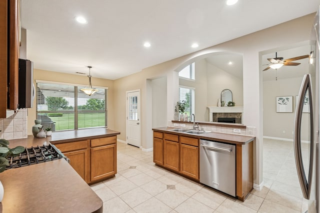 1702 Travis Ct, Allen, TX 75002 - kitchen with stainless steel dishwasher, a sink, a peninsula, a fireplace, and a ceiling fan
