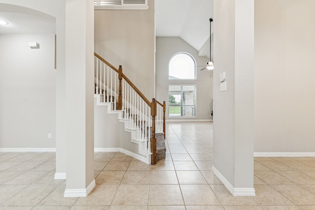1702 Travis Ct, Allen, TX 75002 - staircase with tile patterned flooring, high vaulted ceiling, arched walkways, ceiling fan, and baseboards