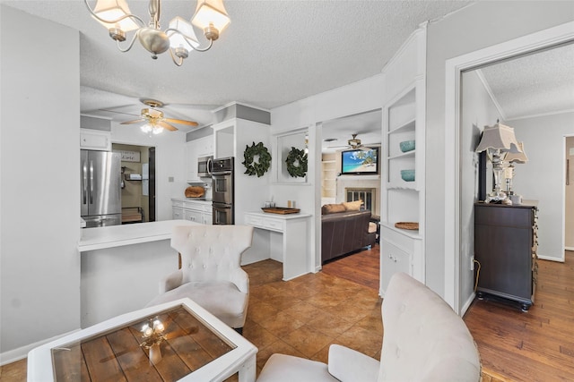 5 Scott Pl, Abilene, TX 79601 - living area with a textured ceiling, a ceiling fan, a chandelier, ornamental molding, and a glass covered fireplace