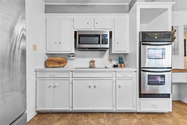 5 Scott Pl, Abilene, TX 79601 - kitchen with stainless steel appliances, light countertops, white cabinetry, crown molding, and light tile patterned flooring