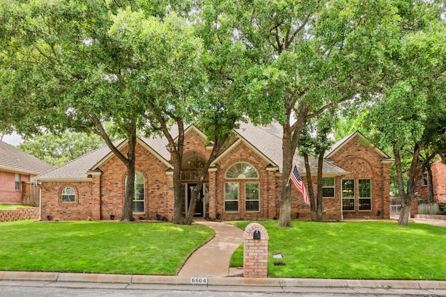 6604 Nantucket Ln, Arlington, TX 76001 - view of front of house featuring brick siding, a front yard, and roof with shingles