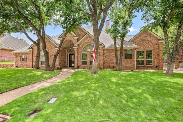6604 Nantucket Ln, Arlington, TX 76001 - traditional-style home with brick siding, a front lawn, a shingled roof, and a chimney
