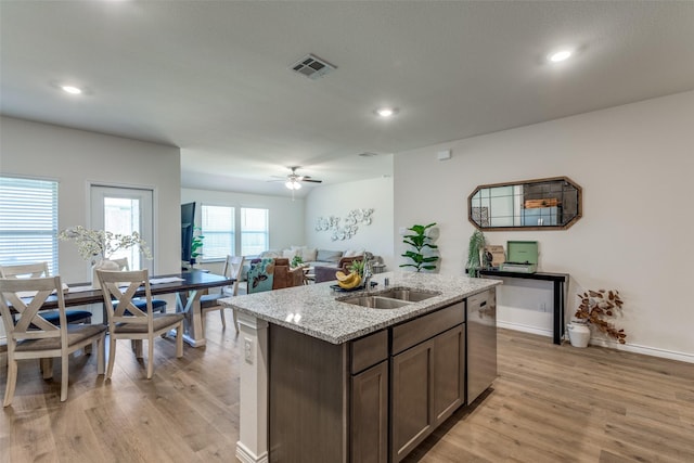 708 Cool Canyon Trl, Princeton, TX 75407 - kitchen with appliances with stainless steel finishes, a sink, light wood finished floors, a kitchen bar, and an island with sink