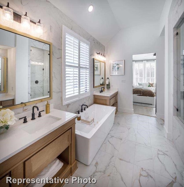 2507 Miranda Ln, Rockwall, TX 75087 - ensuite bathroom featuring vaulted ceiling, a shower stall, a freestanding tub, marble look tile flooring, and two vanities