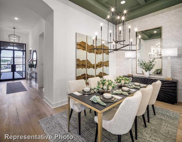 2507 Miranda Ln, Rockwall, TX 75087 - dining area featuring a chandelier, baseboards, wood finished floors, arched walkways, and coffered ceiling