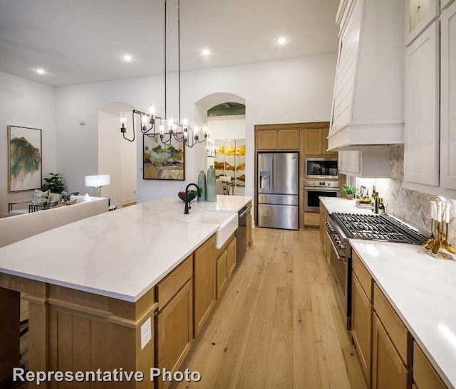 2507 Miranda Ln, Rockwall, TX 75087 - kitchen with stainless steel appliances, a sink, custom range hood, arched walkways, and recessed lighting
