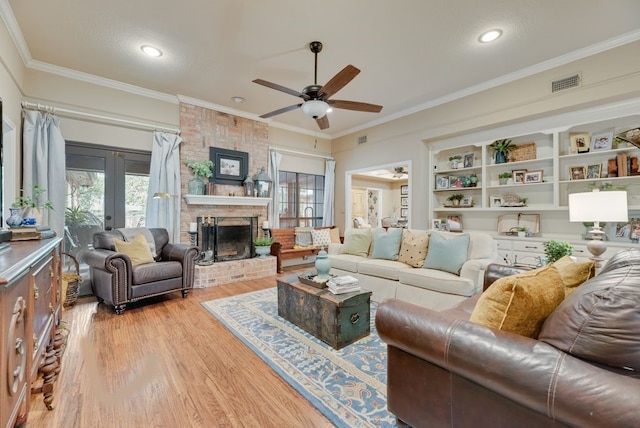 233 Shields Dr, Trophy Club, TX 76262 - living room with ceiling fan, light wood-style flooring, crown molding, french doors, and a fireplace