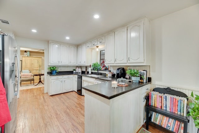 233 Shields Dr, Trophy Club, TX 76262 - kitchen featuring a peninsula, dark countertops, a sink, stainless steel fridge with ice dispenser, and light wood-type flooring