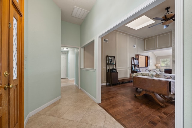 3907 Meadow Dr, Grapevine, TX 76051 - hall featuring light tile patterned flooring, a skylight, a high ceiling, and baseboards