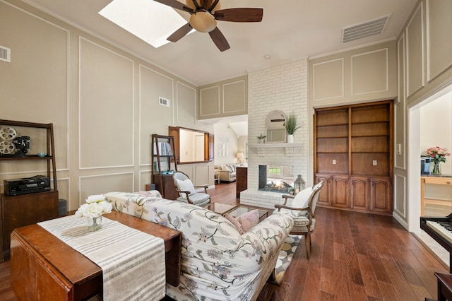3907 Meadow Dr, Grapevine, TX 76051 - living area with a decorative wall, ceiling fan, dark wood finished floors, a fireplace, and a skylight