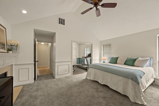 3907 Meadow Dr, Grapevine, TX 76051 - carpeted bedroom with high vaulted ceiling, wainscoting, a ceiling fan, and a tiled fireplace