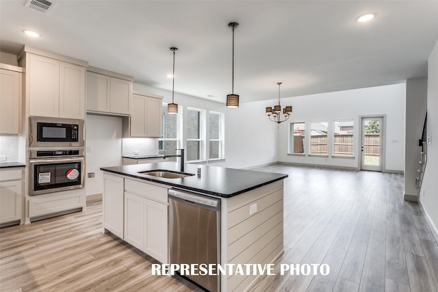 5609 Golden Sun Ln, Mckinney, TX 75070 - kitchen with stainless steel appliances, a sink, dark countertops, decorative backsplash, and recessed lighting