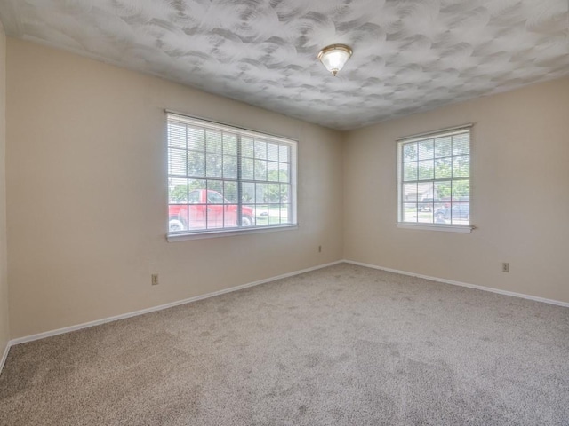 2504 W Rochelle Rd, Irving, TX 75062 - empty room featuring plenty of natural light, carpet floors, baseboards, and a textured ceiling
