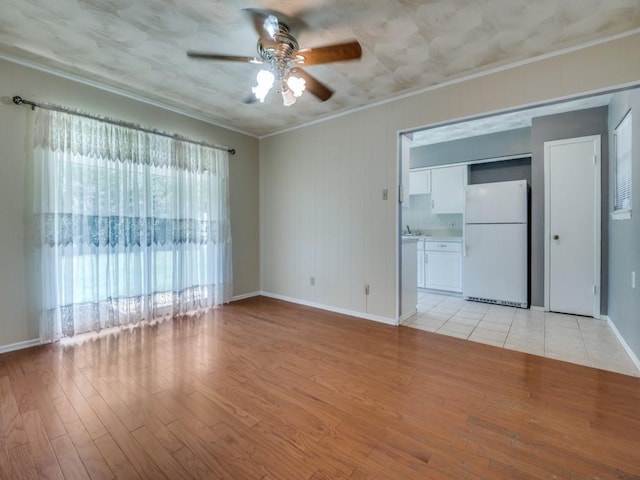 2504 W Rochelle Rd, Irving, TX 75062 - spare room featuring ornamental molding, a ceiling fan, light wood finished floors, and baseboards