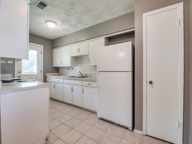2504 W Rochelle Rd, Irving, TX 75062 - kitchen featuring white appliances, a sink, light countertops, white cabinets, and light tile patterned flooring