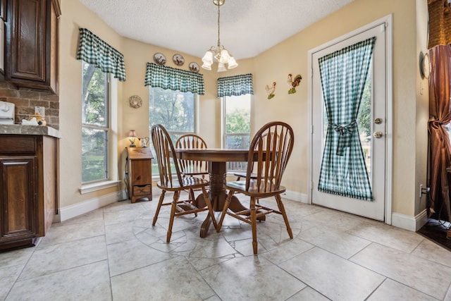 202 Yosemite Dr, Mansfield, TX 76063 - dining room featuring healthy amount of natural light, a textured ceiling, a chandelier, and baseboards