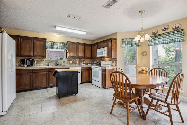 202 Yosemite Dr, Mansfield, TX 76063 - kitchen featuring white appliances, a sink, light countertops, a chandelier, and decorative backsplash